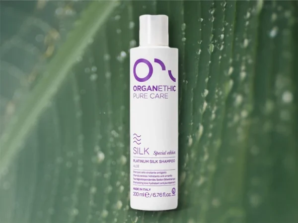 Silk Platinum Shampoo Bottle standing in front of an Aloe Vera Leaf.