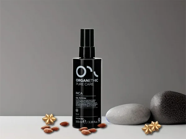 Bottle Inca Illuminating restructuring oil potion, with scattered almonds and Inca flowers.