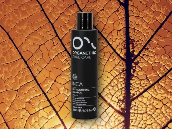 Bottle of Inca restructuring shampoo on a large golden leaf.