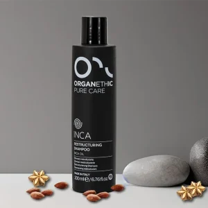 Restructuring shampoo bottle with scattered almonds and Inca Flowers