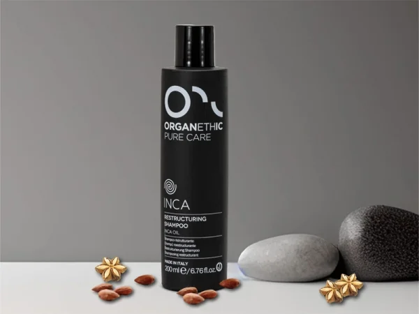 Restructuring shampoo bottle with scattered almonds and Inca Flowers