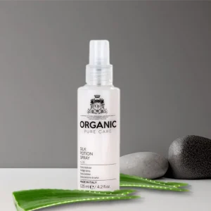 Bottle of silk potion spray surrounded by aloe vera leaves.