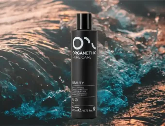 Organethic Pure Care Beauty Shampoo with a background of the sea.